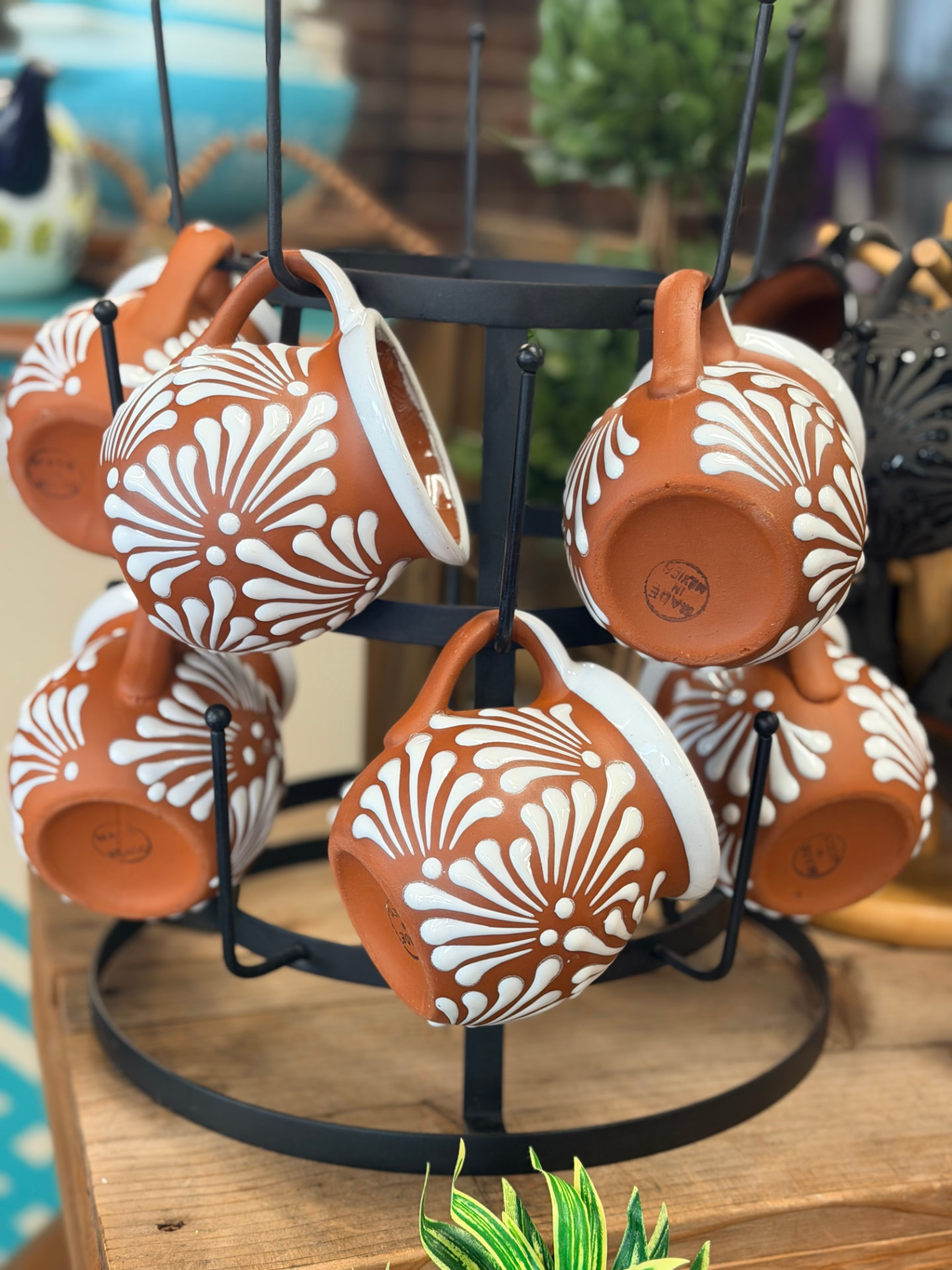 Terracotta mugs with white floral painting on a mug tree